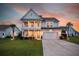 Charming two-story home with a double front porch, a well-manicured lawn, and a two-car garage at 682 Pontoon Rd, Huger, SC 29450
