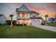 Charming two-story home with a double front porch, a well-manicured lawn, and a two-car garage at 682 Pontoon Rd, Huger, SC 29450