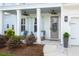 Inviting front porch with comfortable seating, stylish decor, and a well-manicured garden at 682 Pontoon Rd, Huger, SC 29450