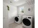 Well-lit laundry room with modern washer and dryer units, storage, and nature-themed decor at 682 Pontoon Rd, Huger, SC 29450
