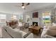 Spacious living room with a fireplace, stylish furniture, and a dining area with access to the patio at 682 Pontoon Rd, Huger, SC 29450