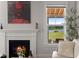 Cozy living room with a fireplace, Buddha art, and a view of the backyard and lake at 682 Pontoon Rd, Huger, SC 29450