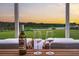 A wine bottle and two glasses sit on a table looking at a beautiful lake view at sunset at 682 Pontoon Rd, Huger, SC 29450