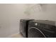 Modern laundry room with black front load washer and dryer set and wire shelving at 700 Silver Moss Dr, Moncks Corner, SC 29461