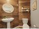 Stylish powder room features a pedestal sink, decorative mirror, and rustic wood wall at 700 Silver Moss Dr, Moncks Corner, SC 29461
