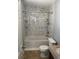 Recently renovated bathroom with tub, shower, and marble effect walls at 7733 Buck Pond Rd, North Charleston, SC 29418