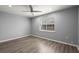 This is a spacious bedroom with hardwood floors, ceiling fan, and a sun-lit window at 7733 Buck Pond Rd, North Charleston, SC 29418