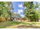 Backyard with a covered porch, wooden fence, and mature trees, offering a serene outdoor space at 841 Fred St, Charleston, SC 29412