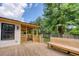 Spacious wooden deck with bench seating and a covered area, surrounded by lush greenery and blue skies at 841 Fred St, Charleston, SC 29412
