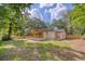 Rear exterior view of a house with a covered porch and fenced yard, surrounded by mature trees at 841 Fred St, Charleston, SC 29412