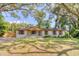 Charming single-story home featuring a white brick exterior, wood accents, and a beautifully landscaped front yard at 841 Fred St, Charleston, SC 29412
