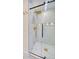 Modern shower with glass door, marble tile, a rainfall shower head, and gold fixtures at 841 Fred St, Charleston, SC 29412