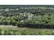 Expansive aerial shot showing a neighborhood bordering a wooded area and a golf course with a pond at 8662 W Fairway Woods Dr, North Charleston, SC 29420
