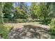 Lush backyard featuring mature trees, landscaping, and a stone pathway at 8662 W Fairway Woods Dr, North Charleston, SC 29420