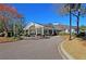 Beautiful clubhouse with covered entrance and circular driveway, surrounded by lush landscaping at 8662 W Fairway Woods Dr, North Charleston, SC 29420