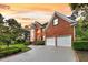 Beautiful two-story brick home with manicured lawn, mature trees and two-car garage at dusk at 8662 W Fairway Woods Dr, North Charleston, SC 29420