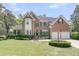 Elegant brick home with a manicured lawn, mature landscaping, and a two-car garage at 8662 W Fairway Woods Dr, North Charleston, SC 29420