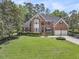 Charming brick home featuring a manicured lawn, mature trees, and an attached two-car garage at 8662 W Fairway Woods Dr, North Charleston, SC 29420