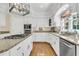Well-lit kitchen with white cabinets, granite countertops, and stainless steel appliances at 8662 W Fairway Woods Dr, North Charleston, SC 29420
