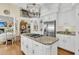 Granite topped kitchen island with cooktop, white cabinets and stainless refrigerator at 8662 W Fairway Woods Dr, North Charleston, SC 29420