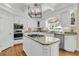 Modern kitchen with granite countertops, stainless steel appliances, and a center island cooktop at 8662 W Fairway Woods Dr, North Charleston, SC 29420