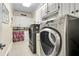 A modern laundry room with front loading washer and dryer and custom cabinets for storage at 8662 W Fairway Woods Dr, North Charleston, SC 29420