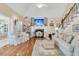 A comfy living room is shown with white sofas, fireplace and hardwood floors at 8662 W Fairway Woods Dr, North Charleston, SC 29420