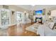 Sun-drenched living room featuring hardwood floors and stylish white furniture at 8662 W Fairway Woods Dr, North Charleston, SC 29420