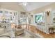 Bright living room with hardwood floors, white sofas, and adjacent sunroom at 8662 W Fairway Woods Dr, North Charleston, SC 29420
