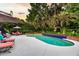 Gorgeous backyard pool with lounge chairs and patio furniture surrounded by lush landscaping and palm trees at 8662 W Fairway Woods Dr, North Charleston, SC 29420
