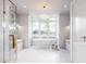 Bright bathroom featuring a soaking tub under a large window, a glass-enclosed shower, and stylish finishes at 952 Mccants Dr, Mount Pleasant, SC 29464