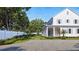 Expansive home exterior showcasing a long porch, manicured lawn, stone driveway, and a white privacy fence at 952 Mccants Dr, Mount Pleasant, SC 29464