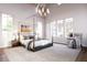 Serene main bedroom with a four-poster bed, hardwood floors, large windows, and a cozy sitting area for relaxation at 952 Mccants Dr, Mount Pleasant, SC 29464