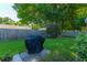 Spacious backyard featuring a well-maintained lawn, mature trees, and a barbecue grill covered for protection at 9590 Crosscut Dr, Ladson, SC 29456