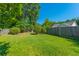 Well-maintained backyard with a lush green lawn, mature trees, and a wood fence for privacy at 9590 Crosscut Dr, Ladson, SC 29456