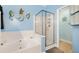 Bathroom showcasing a garden tub with jets and a glass-enclosed shower on blue walls decorated with sea creatures at 9590 Crosscut Dr, Ladson, SC 29456