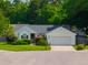Charming one-story home with manicured lawn, lush landscaping, and attached two-car garage in a suburban neighborhood at 9590 Crosscut Dr, Ladson, SC 29456
