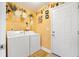 Bright laundry room with white washer and dryer, shelving, and painted yellow walls at 9590 Crosscut Dr, Ladson, SC 29456
