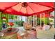 Outdoor patio featuring comfortable seating under a red canopy, complimented by tropical plants and decor at 9590 Crosscut Dr, Ladson, SC 29456