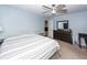 Bright bedroom featuring a ceiling fan, a striped bedspread, and a dark wood dresser with a mirror at 100 Pine Hall Dr, Goose Creek, SC 29445
