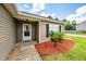 Inviting front porch with decorative landscape and mulch, leading to a charming tan-sided home with a white door at 100 Pine Hall Dr, Goose Creek, SC 29445