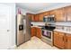 Well-equipped kitchen with stainless steel appliances, wood cabinets, tile flooring, and white countertops at 100 Pine Hall Dr, Goose Creek, SC 29445