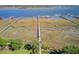 Scenic aerial view of a waterway, docks, boat lift and grassy wetlands leading to a residential area at 104 Wando Reach Rd, Wando, SC 29492