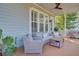 Cozy back porch with wicker furniture, ceiling fan, and wood flooring provides a relaxing outdoor space at 104 Wando Reach Rd, Wando, SC 29492