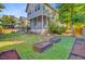 Large, landscaped backyard featuring a screened porch, stone patio, raised garden beds, and privacy fence at 104 Wando Reach Rd, Wando, SC 29492
