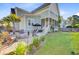 Expansive backyard with lush lawn, firepit, patio area, and screened-in porch offers inviting outdoor living at 104 Wando Reach Rd, Wando, SC 29492