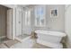 Bathroom featuring modern tub, glass shower, and window with plantation shutters at 104 Wando Reach Rd, Wando, SC 29492