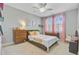 Inviting bedroom with a bed, two dressers, and a window with pink curtains at 104 Wando Reach Rd, Wando, SC 29492