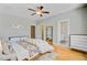 Light-filled bedroom with wood floors, ceiling fan, and view to bathroom at 104 Wando Reach Rd, Wando, SC 29492