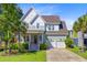 Charming two-story home features a landscaped yard, covered porch, and two-car garage at 104 Wando Reach Rd, Wando, SC 29492